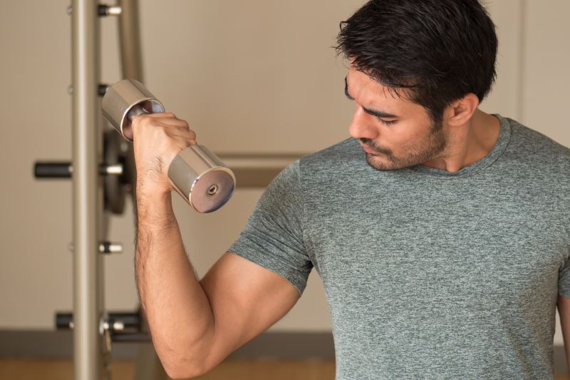 Woman standing on a scale and holding a tape measure around her waist.